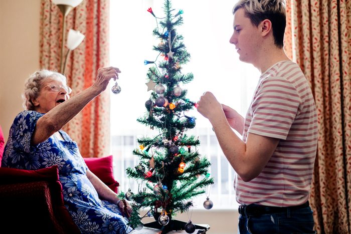 Helping an Elderly Woman Decorate her Christmas Tree