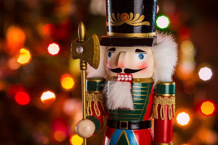 nutcracker in front of christmas tree lights