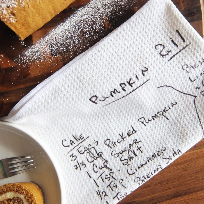 towel with printed handwritten recipe for pumpkin rolls on a kitchen counter