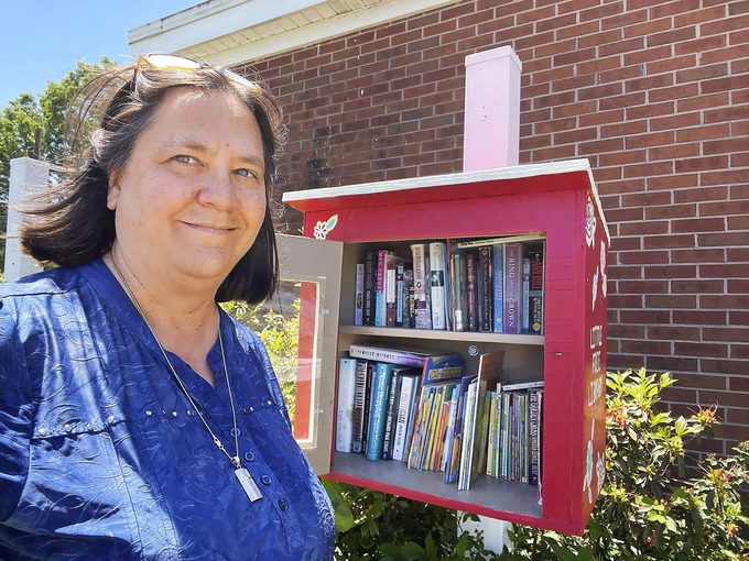 Selfie of Jennifer Williams in front of her little free library.