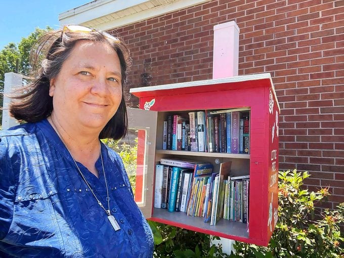 Selfie of Jennifer Williams in front of her little free library.