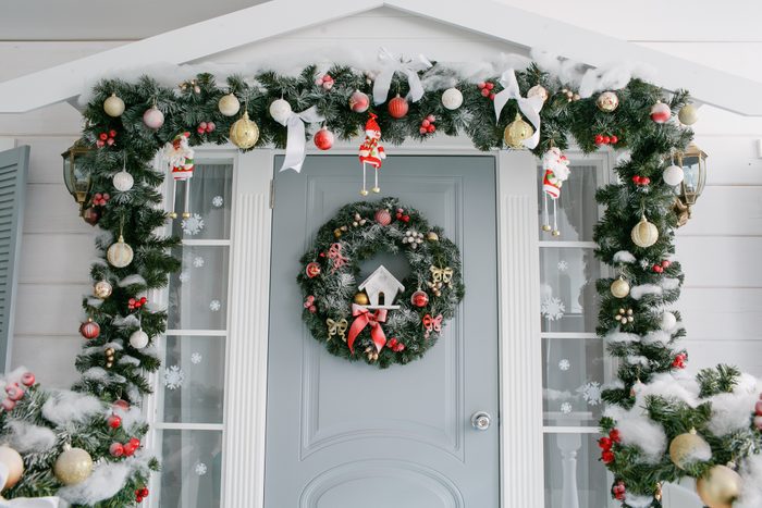 decorated front door with christmas wreath and garland