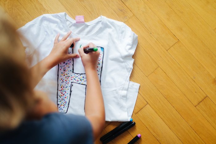 Little Girl Decorating T-Shirt with fabric marker