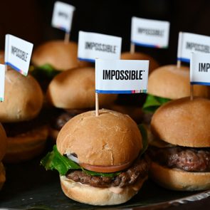 tray of impossible burger sliders each with toothpick flags that say, 