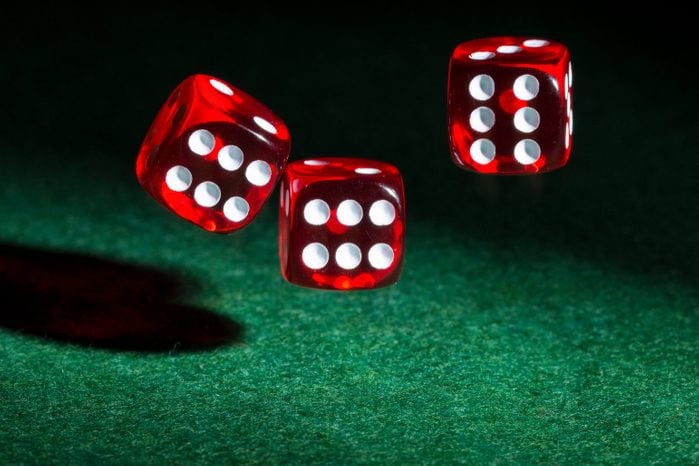 three red dice over green table