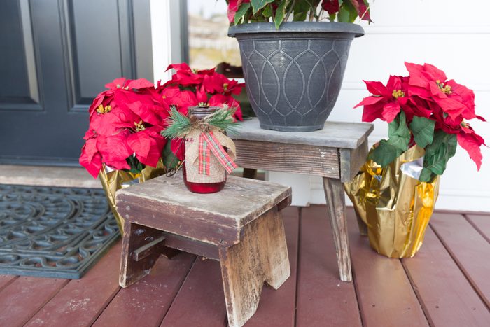 wood benches and poinsettias Christmas Decorations At Front Door of House