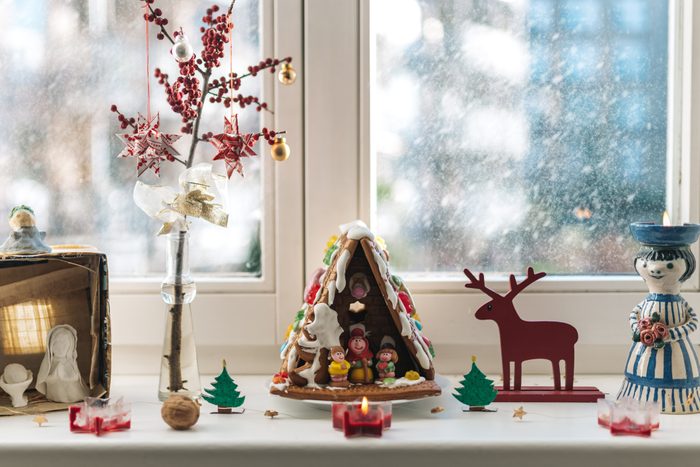 gingerbread house and christmas decoration on window sill