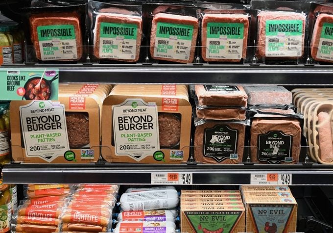 Packages of "Impossible Burger" and "Beyond Meat" sit on a shelf for sale in a grocery store