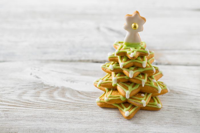 Gingerbread christmas cookie tree on white wooden surface