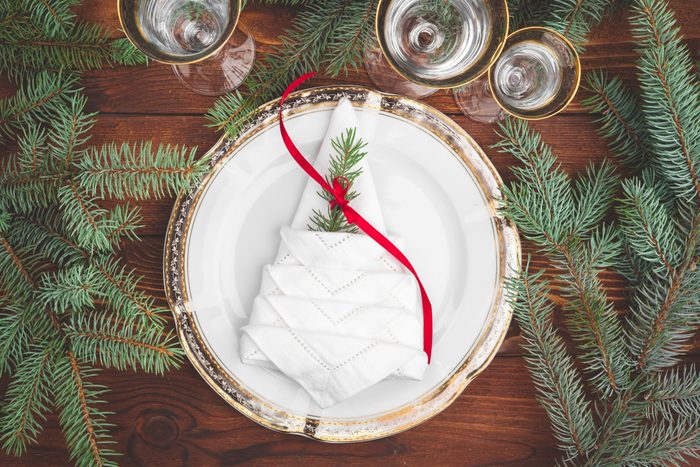 Christmas table setting with pine tree branches and decorations top view