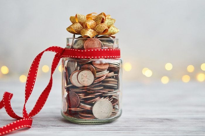 Holiday Savings Jar Filled with Coins and Christmas Ribbon and Bow