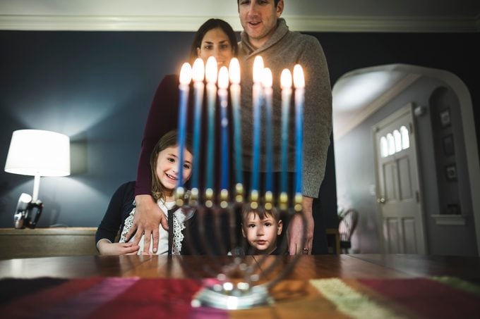 Family looking at menorah during Hanukkah celebration