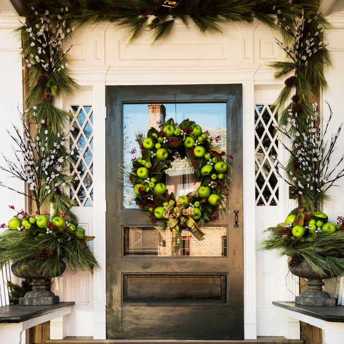 A beautifully apple decorated front door and porch ready for the holidays