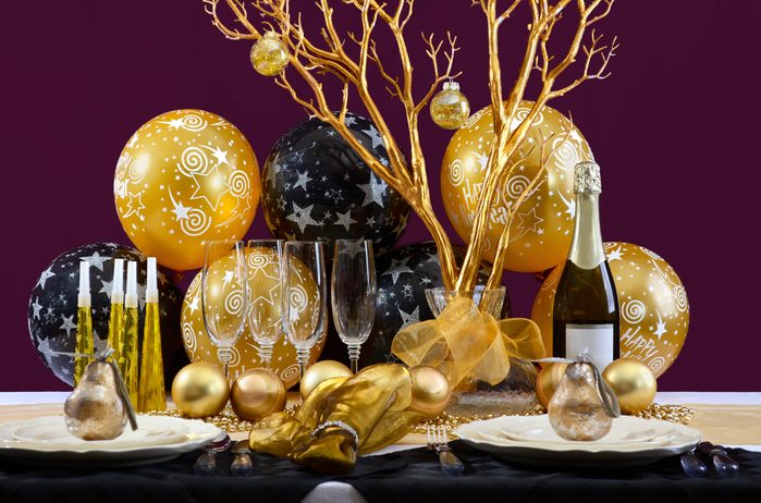 black and gold new year's party decorations on a table