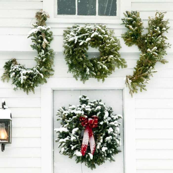 Christmas decorations on door of house that spell joy