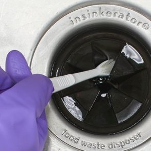 cleaning garbage disposal with a tooth brush