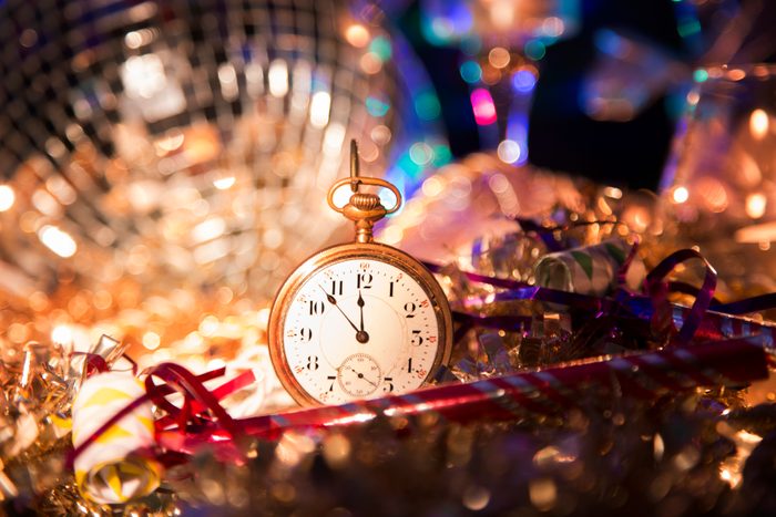 small clock surrounded by new year's eve party decorations