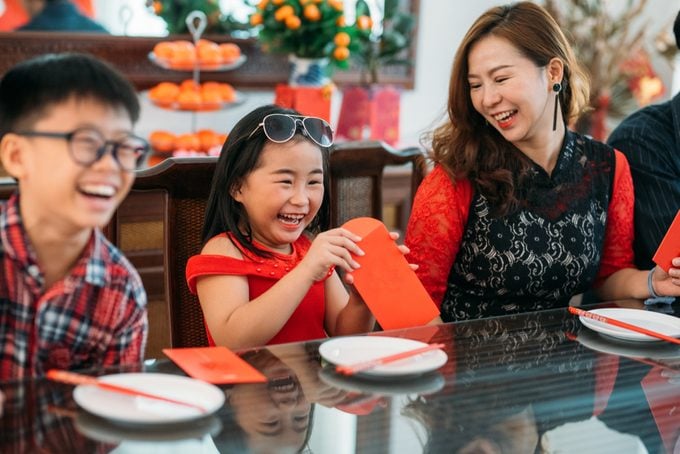 family opening red envelopes in celebration of the chinese new year
