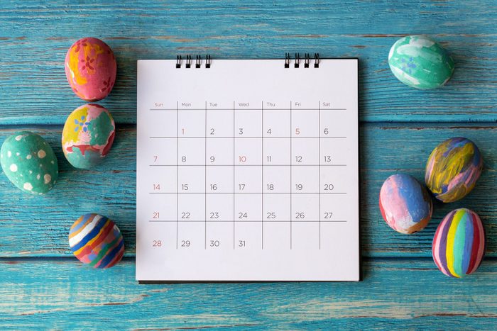 calendar on blue wood background with easter eggs