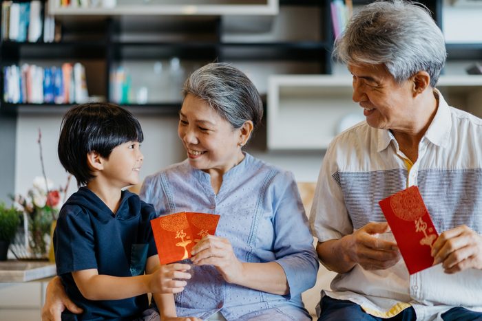 Grandparents giving red envelope to their grandchild during chinese new year