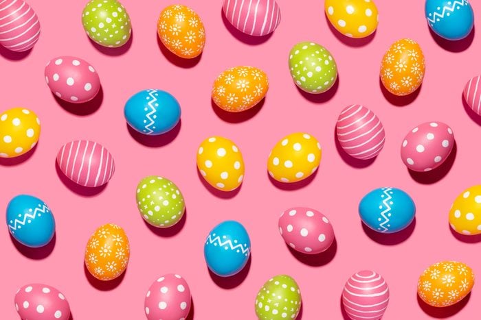 Handmade decorated Easter eggs on pink background