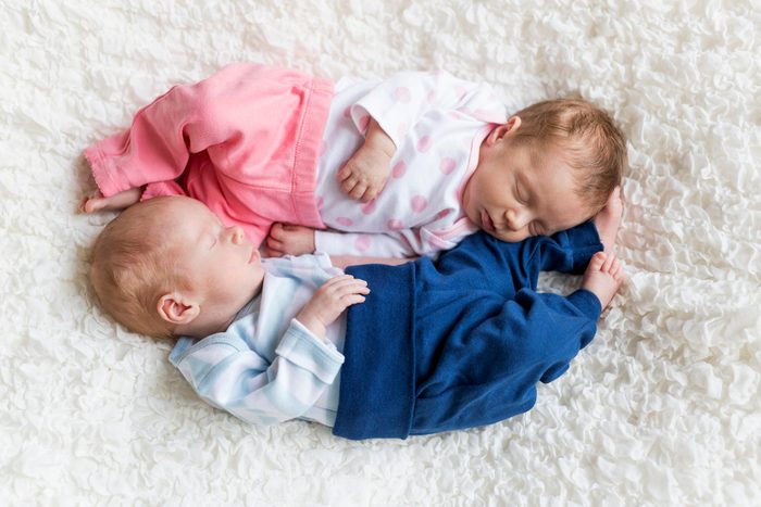 Beyaz battaniye üzerinde uyuyan yeni doğan ikizler