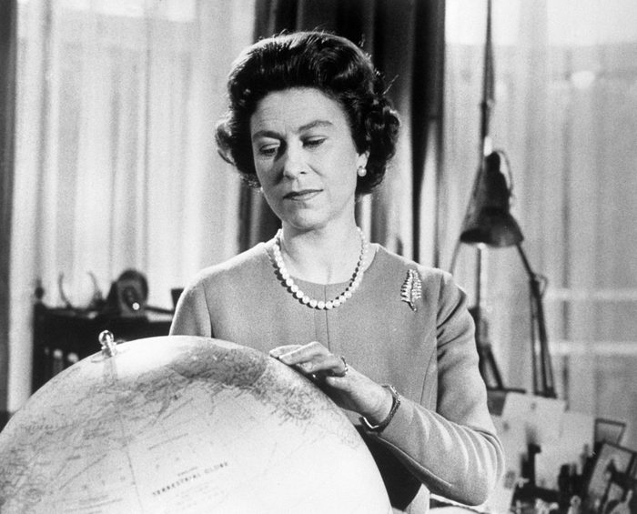 Queen Elizabeth looking at a globe