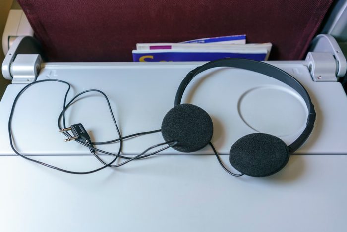 Airplane stereo headphones with two-legged connector placed on folded table