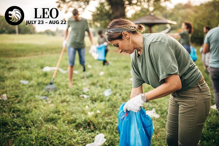 woman picking up trash with a volunteer group