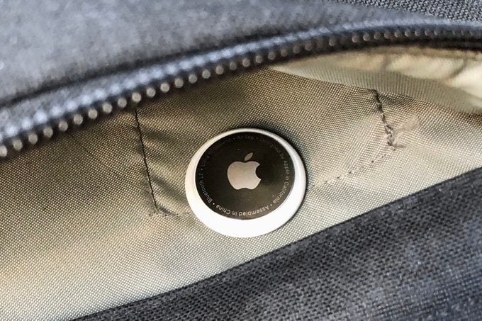 primer plano de una Apple Air Tag en el bolsillo de una mochila abierta