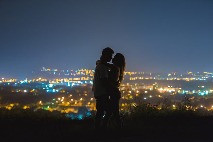 couple standing outside kissing at night