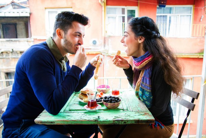 Young couple enjoying Turkish snack on balcony