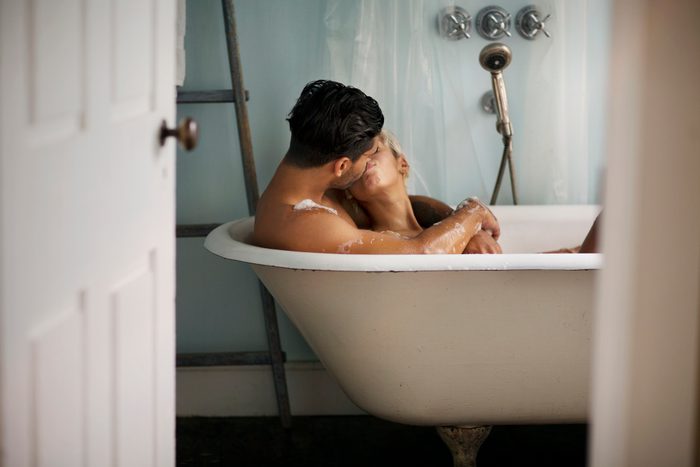 Young couple kissing in bathtub at home