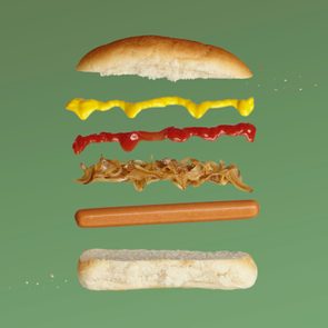 A deconstructed hot dog showing it's various layers against a green background