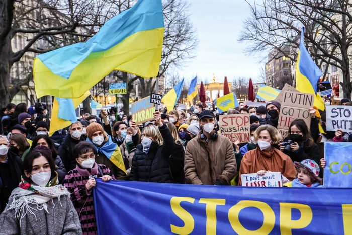 People hold banners and wave Ukraine national flags as they protest Ukraine intervention in front of the Russian Embassy on February 22, 2022 in Berlin, Germany.