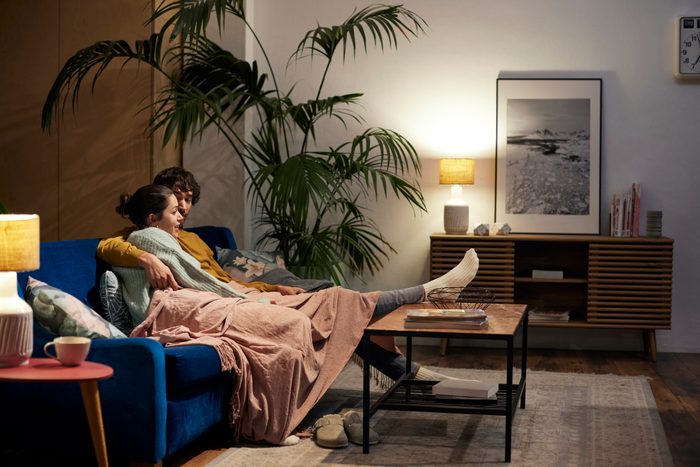 Couple Talking While Watching TV In Living Room