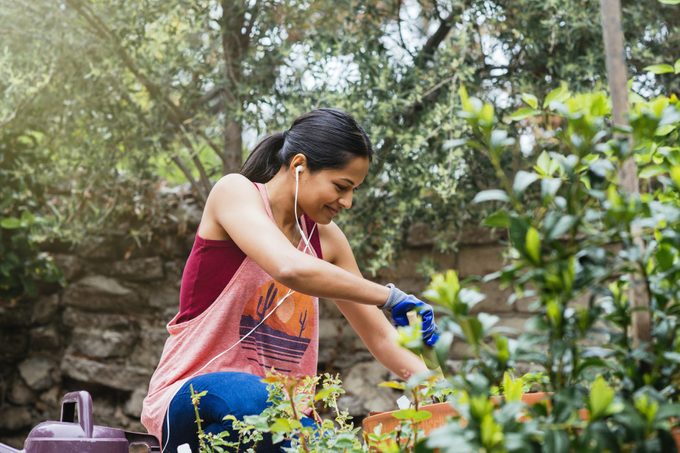 Cheerful woman gardening in backyard