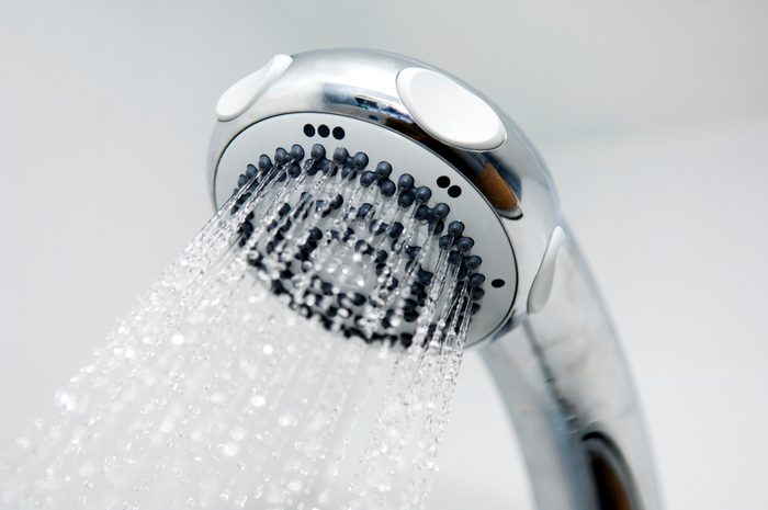 A close-up of a silver chrome shower head spouting water