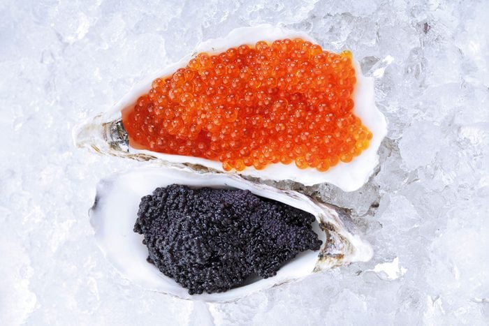 black and orange caviar in oyster shells on ice
