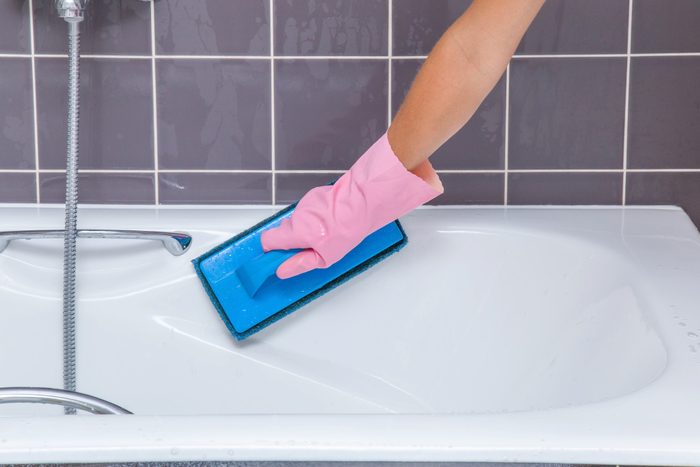 Hand washing tiles and bath with professional cleaning pad.