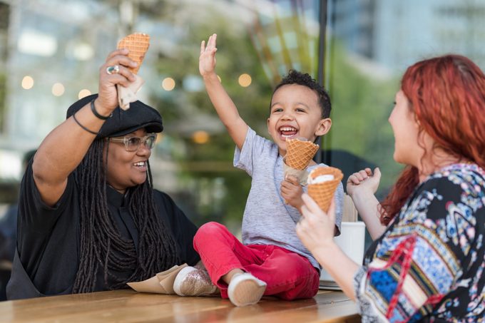 Dos madres comen helado con su hijo de tres años.