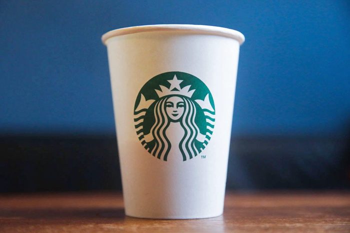 Is Starbucks Done with Disposable Paper Cups Paper Cup on Blue and Wood background