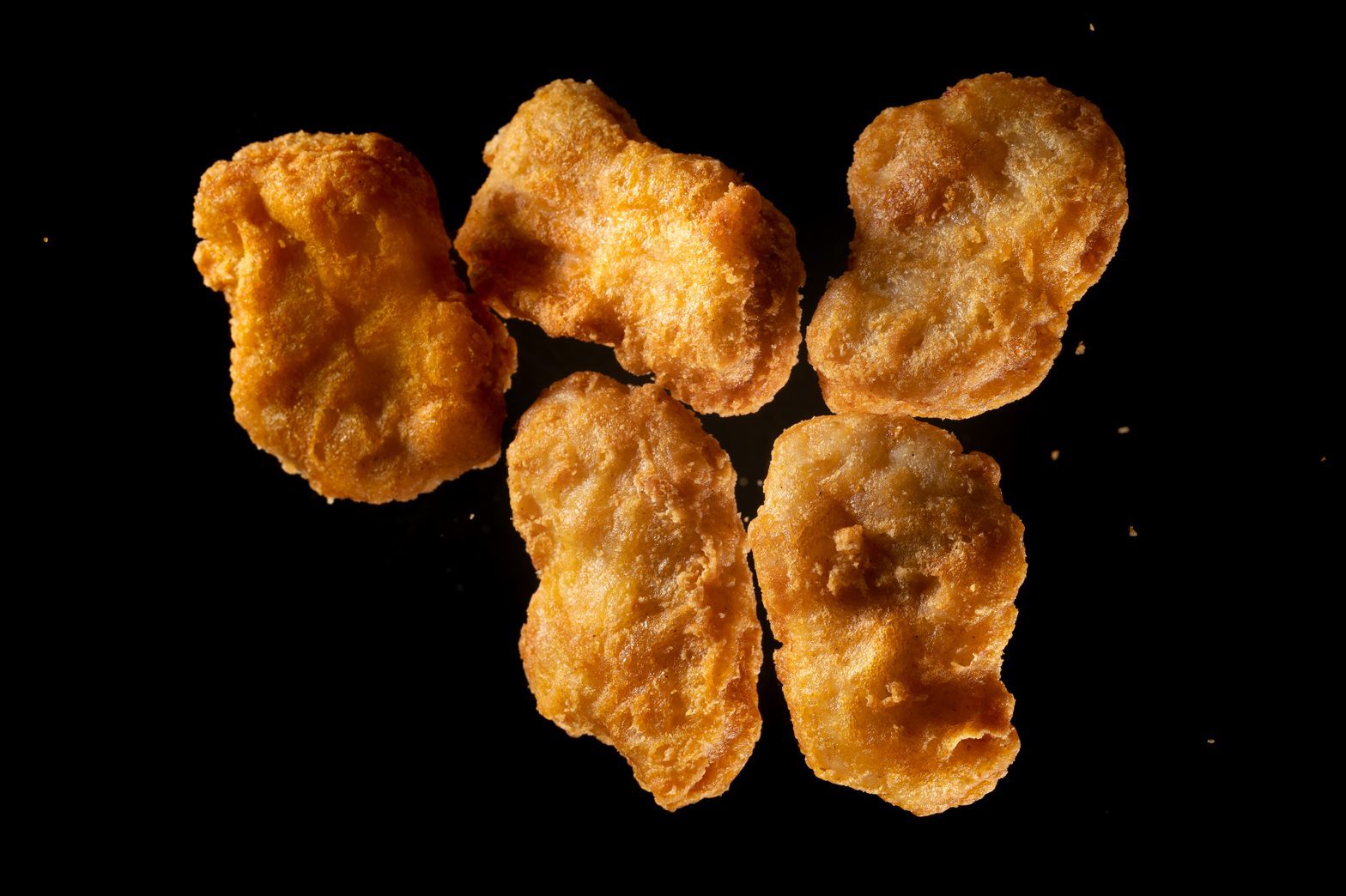 fried chicken Nuggets flying in mid air view from above