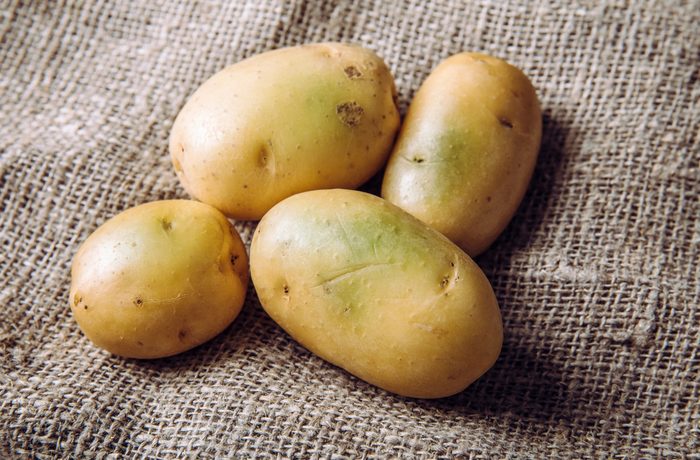 Sunlight And Warmth Turn Potatoes Skin Green Witch Contain High Levels Of A Toxin Solanine Which Can Cause Sickness And Is Poisonous Do Not Buy And Eat Green Potatoes Heap On Sackcloth