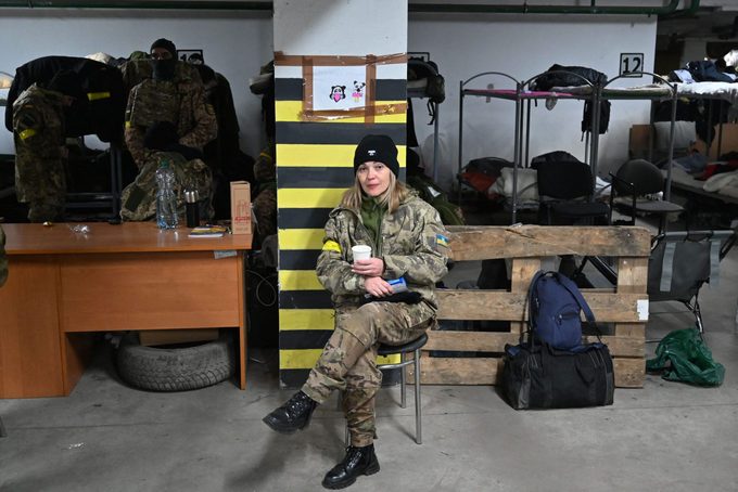 A female soldier of Territorial Defense Forces of Ukraine, the military reserve of the Armed Forces of Ukraine, drinks a tea in an underground garage that has been converted into a training and logistics base in Kyiv, March 11, 2022.