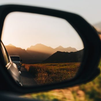 View of mountains reflected in side-view mirror of car at sunset,Teton County,Wyoming,United States,USA