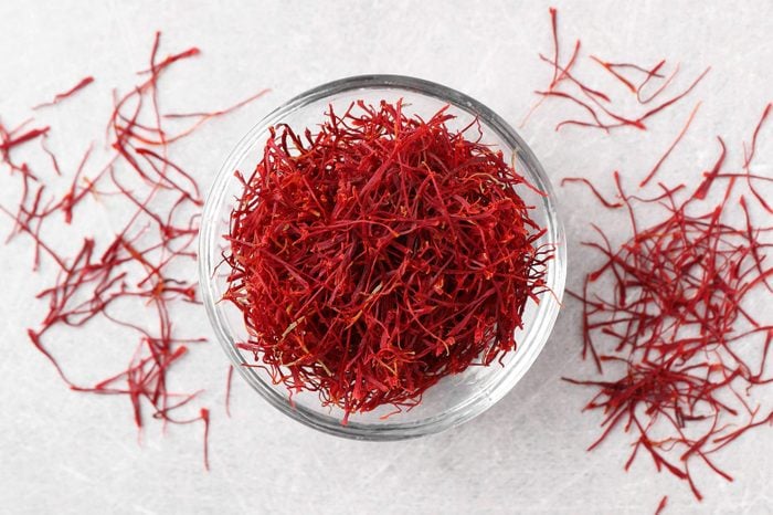 Dried saffron in a glass bowl on grey table