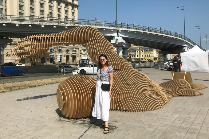 Maria Romanenko standing near an outdoor sculpture in Ukraine
