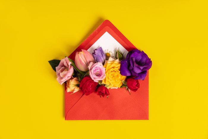 Opened red envelope with flowers arrangements on yellow background