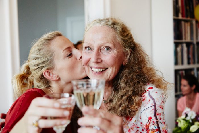 happy friends raise a glass of sparkling wine at a party